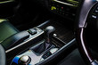 The black leather interior of a luxury European vehicle. Center console with brushed nickel shift knob,