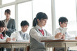 © amanaimages - 教室で授業を受ける学生と女性教師