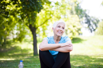 Wall Mural - Portrait of smiling senior woman relaxing after exercising