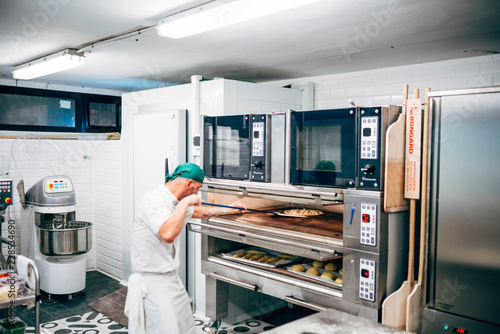 Zdjęcie XXL Człowiek pracuje w restauracji, co pizzy w pizzerii.