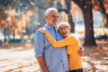 Active Seniors On A Walk In Autumn Forest