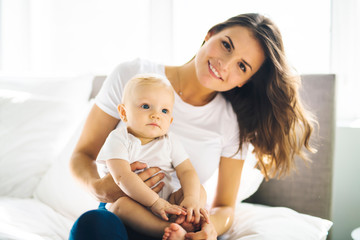 Wall Mural - mother with baby on bed having good time