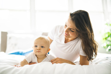 Wall Mural - mother with baby on bed having good time