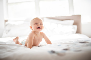 Poster - Cute baby girl lying on white sheet at home