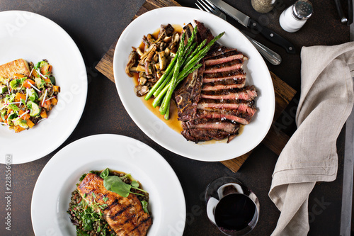 Fotografie, Obraz Overhead shot of a dinner table with steak and salmon