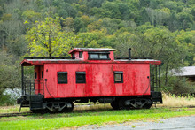 Old Red Caboose Sitting Idle On The Tracks