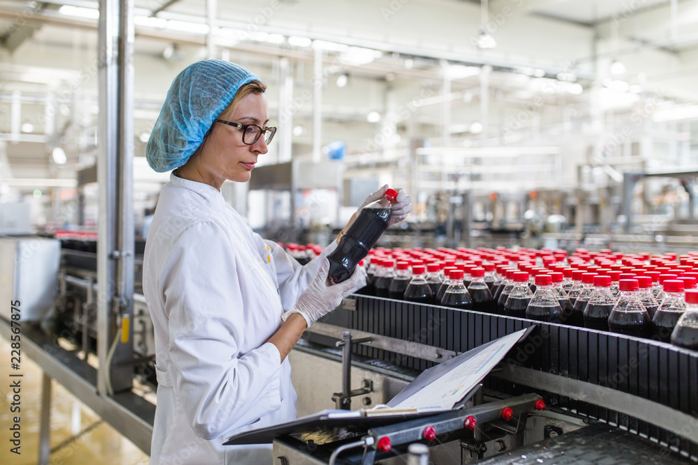 Woman Quality Control Serious middle age woman quality control worker checking robotic line ...