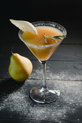 Wall Mural - yellow christmas alcohol cocktail italian pear with pear nearly on the table on dark background