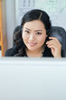 © DragonImages - Smiling female call center operator consulting client