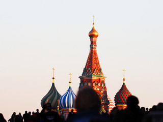 Wall Mural - Domes of Saint Basil's Cathedral against sunset sky, people walk on the Red square (out of focus), Moscow Kremlin, Russia