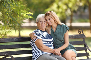 Poster - Woman with elderly mother on bench in park