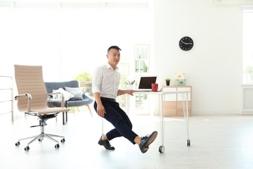 Canvas Print - Young businessman doing exercises in office. Workplace fitness