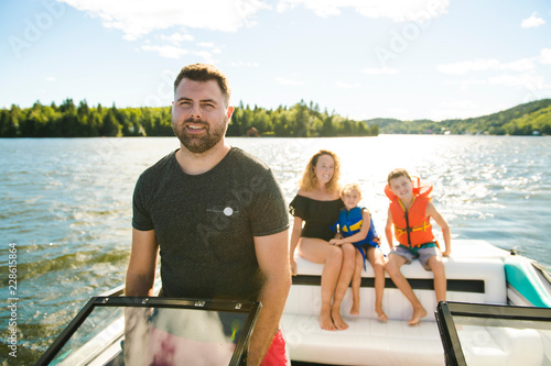 Fotomural Man driving boat on holiday with his son kids and his wife