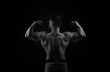 © Vagengeim - Bodybuilder black and white portrait. Muscular man stands back and shows biceps.