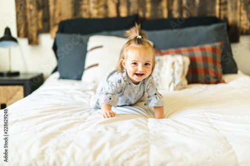 Fototapeta Cute little baby girl on bed at home