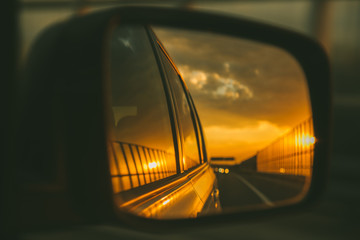 car on highway. sunset in car mirror reflection