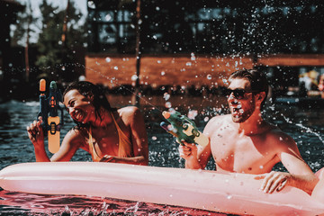 Wall Mural - Young Smiling Couple having Fun in Swimming Pool