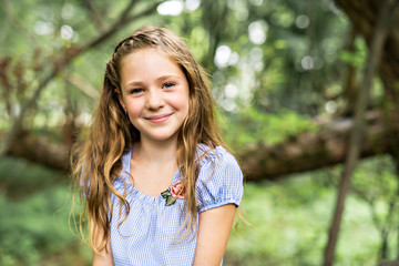 Wall Mural - Portrait of a happy young girl outdoors forest