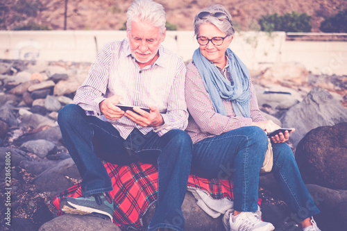 Elderly Couple With White Hair Sitting On Red Blanket Gardano And