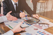 © PhotoJuthamat - Start up business. people team work meeting point to discuss the graph up and down of economy and work on tablet.Selective Focus