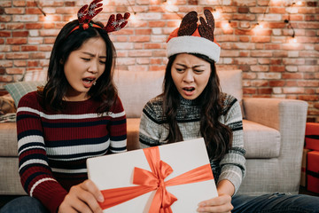 girls open gift box at home feeling displeased