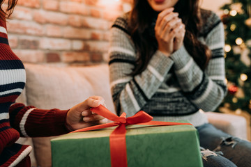 girl pulling the ribbon to open the gift box