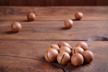 Wall Mural - Macadamia nuts on a wooden background.