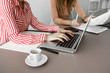 © LUMINA IMAGES - Two unrecognisable businesswomen working together using laptop.