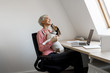 © LUMINA IMAGES - Smiling businesswoman cuddling her dog in office