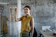 © LUMINA IMAGES - Portrait of beautiful businesswoman writing on glass board and looking at camera.