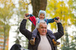 © yavdat - Playful grandfather spending time with his grandson in park on sunny day