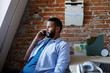 © LUMINA IMAGES - Casual businessman sitting at his office and talking on cell phone.