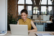 © LUMINA IMAGES - Pretty Caucasian smiling businesswoman sitting at her modern office and typing on her laptop.