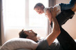 © Louis-Photo - Young father with child girl on bed at home