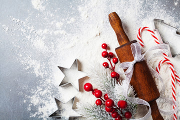 Bakery background for cooking christmas baking with rolling pin and scattered flour decorated with fir tree top view.