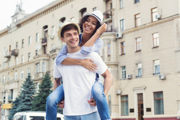 Wall Mural - Diverse couple having fun and enjoying piggyback riding