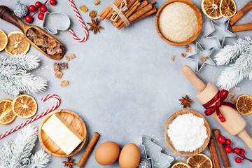 bakery background with ingredients for cooking christmas baking decorated with fir tree. flour, brow