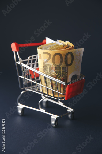 Fotografía shopping cart filled with european currency notes, isolated on white
