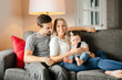 © Louis-Photo - Family mother, father, child daughter at home watching tv