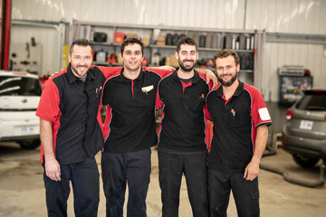 Portrait of auto shop mechanics group together employee