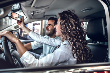 Wall Mural - Young couple in love choosing car dealership.