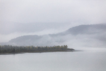 Foggy landscape fog on lake in the morning - Cold autumn winter grey day in Alaska.