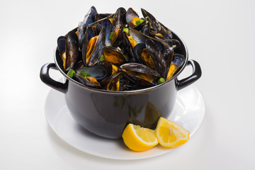 Black pan with cooked with green onion, parsley marinated high quality mussels