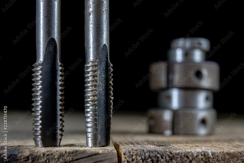 Metalwork tools on the workshop table. Threading dies and taps in an ...