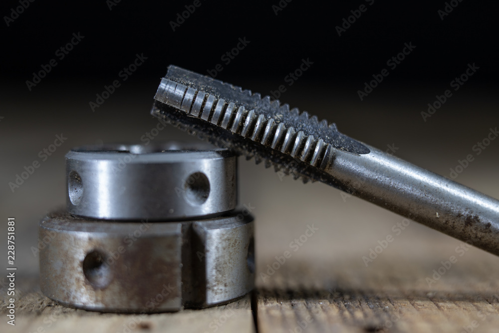 Metalwork tools on the workshop table. Threading dies and taps in an ...