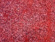 Miniaturowa mozaika z kamieni na czerwonym tle