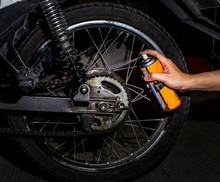Cleaning And Oiling A Motorcycle Chain And Gear With Oil Spray