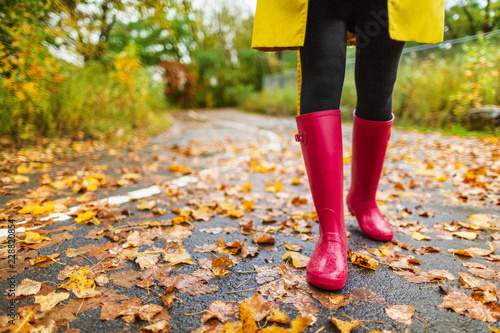 Fotografía Autumn fall city lifestyle colorful leaves and red rain boots woman feet walking in park outside