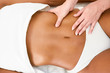 © javiindy - Woman receiving abdomen massage in spa wellness center.