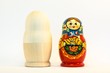 Colorful and unpaiting nesting russian dolls standing side by side on white